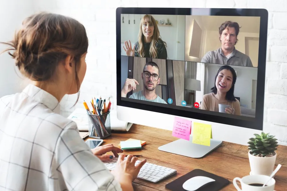 Une femme fait du management hybride en visio conférence sur un ordinateur